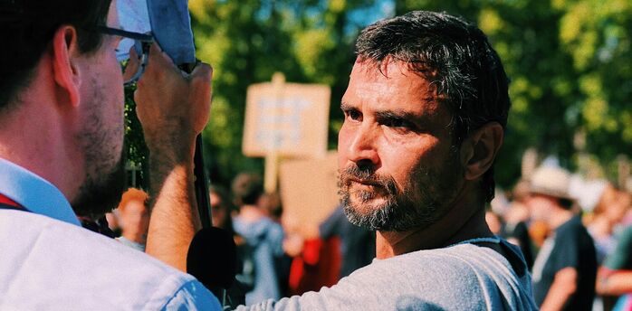 A man speaks to a reporter during a public strike gathering
