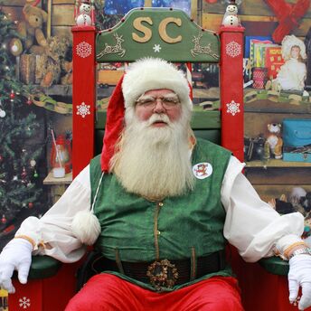 Santa Claus sitting in a decorated Christmas setting