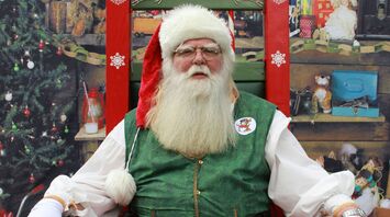 Santa Claus sitting in a decorated Christmas setting