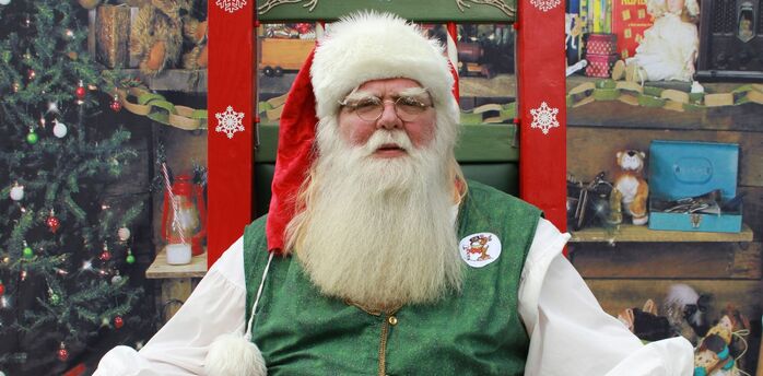 Santa Claus sitting in a decorated Christmas setting