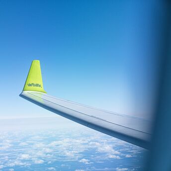 airBaltic aircraft wing in flight during summer travel