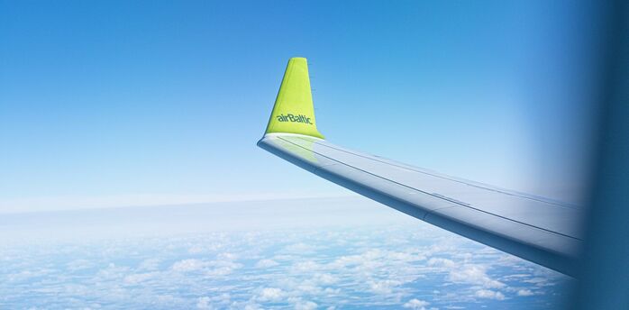 airBaltic aircraft wing in flight during summer travel