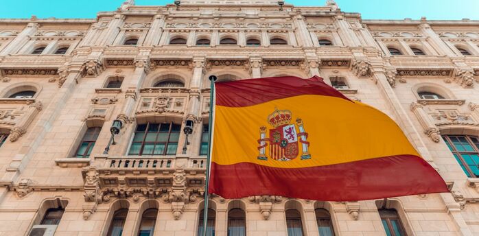 Spanish flag waving outside a historic building in Madrid
