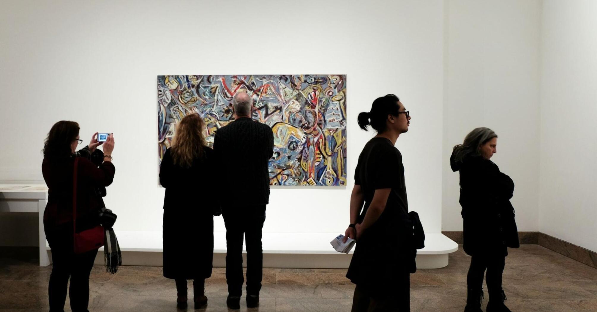 Visitors observing a contemporary artwork in a quiet museum gallery