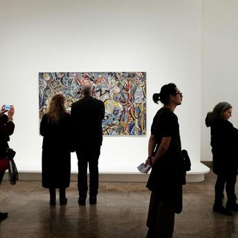 Visitors observing a contemporary artwork in a quiet museum gallery
