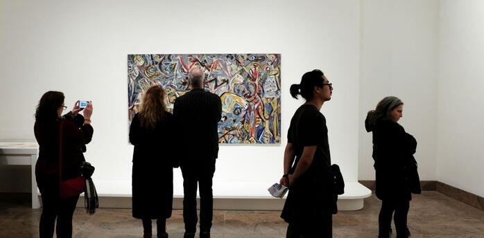 Visitors observing a contemporary artwork in a quiet museum gallery