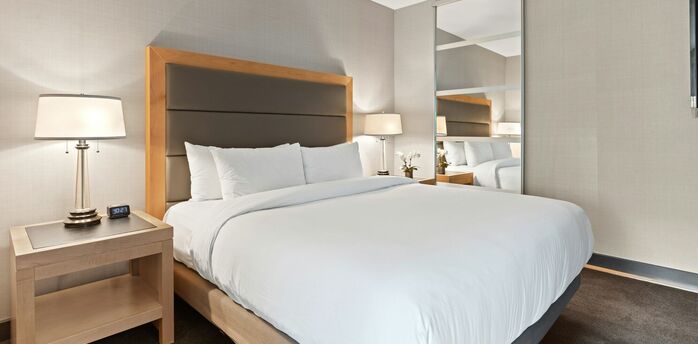 Modern hotel room with neutral decor and large bed