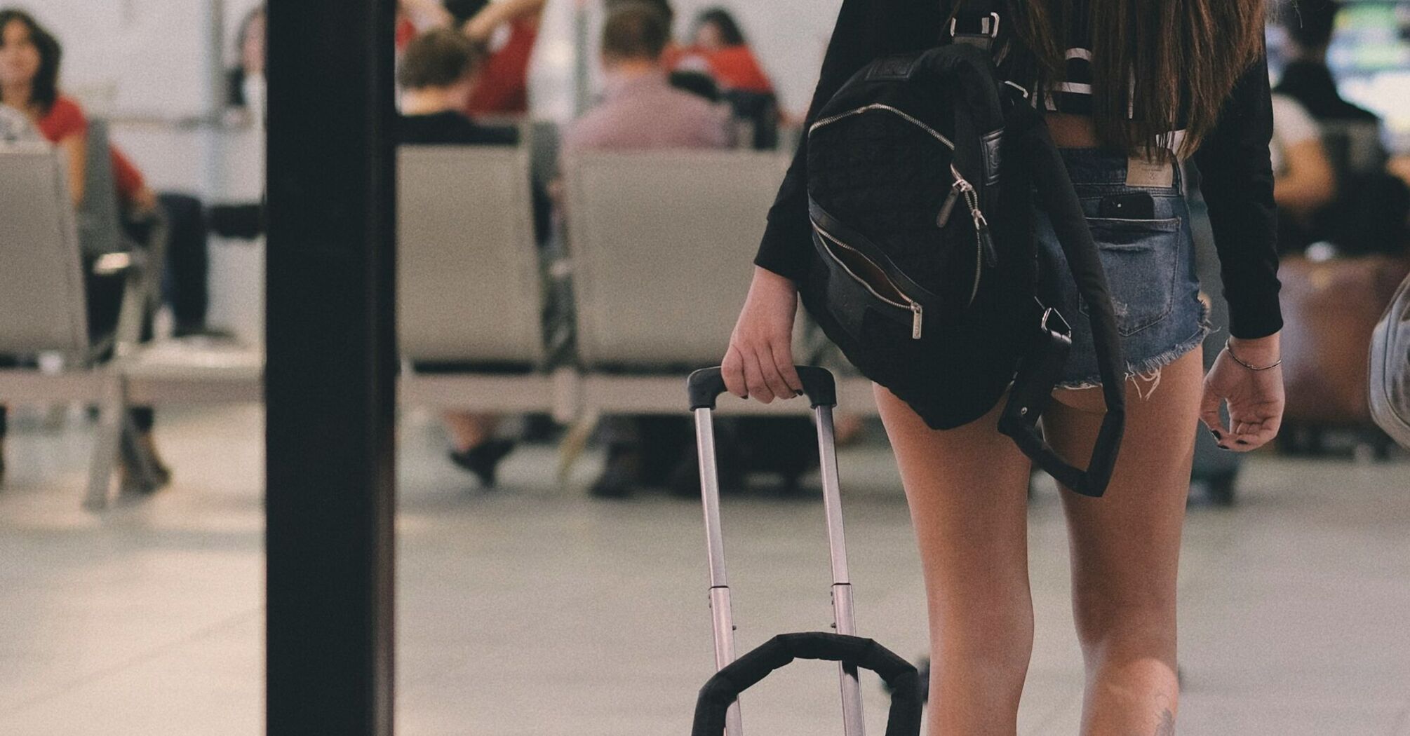 Passenger using luggage trolley inside airport terminal