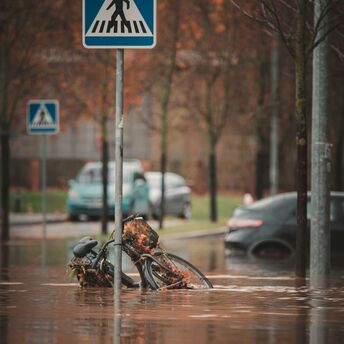 Flooded street with submerged bicycle and traffic sign