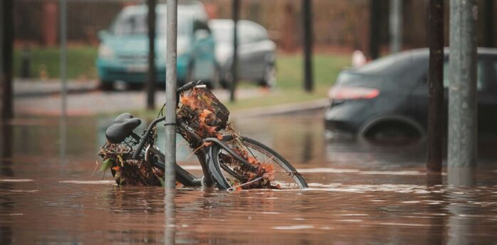 Flooded street with submerged bicycle and traffic sign