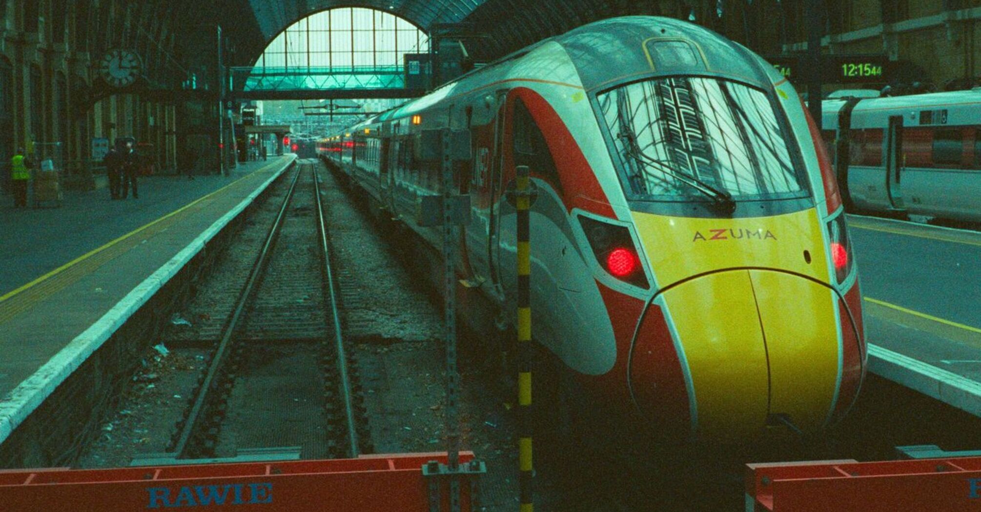 A modern passenger train stopped at a covered station platform