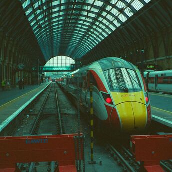 A modern passenger train stopped at a covered station platform