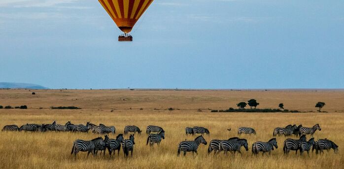 Hot air balloon over safari landscape in Kenya