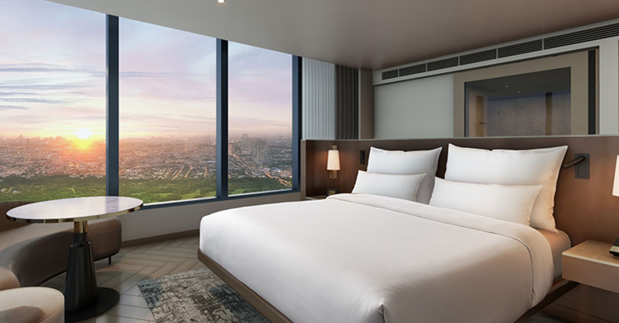 Hotel room with large windows overlooking Manila at sunset