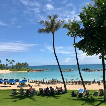 Crowded beach in Hawaii with visitors relaxing near the ocean on a sunny day