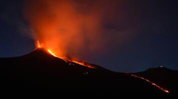 Lava and ash erupting from Mount Etna at night.