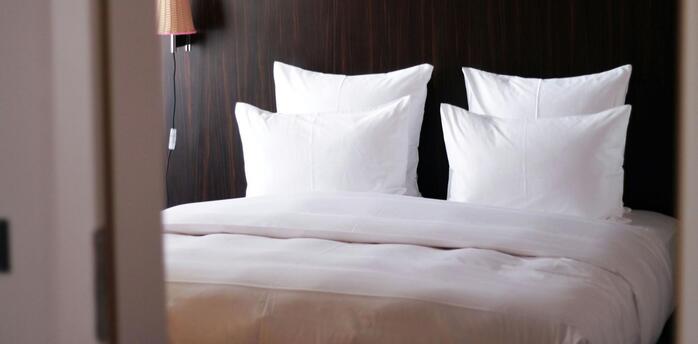 Modern hotel room with fresh white bedding