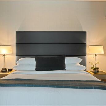 Modern hotel room with soft lighting and a neatly arranged bed