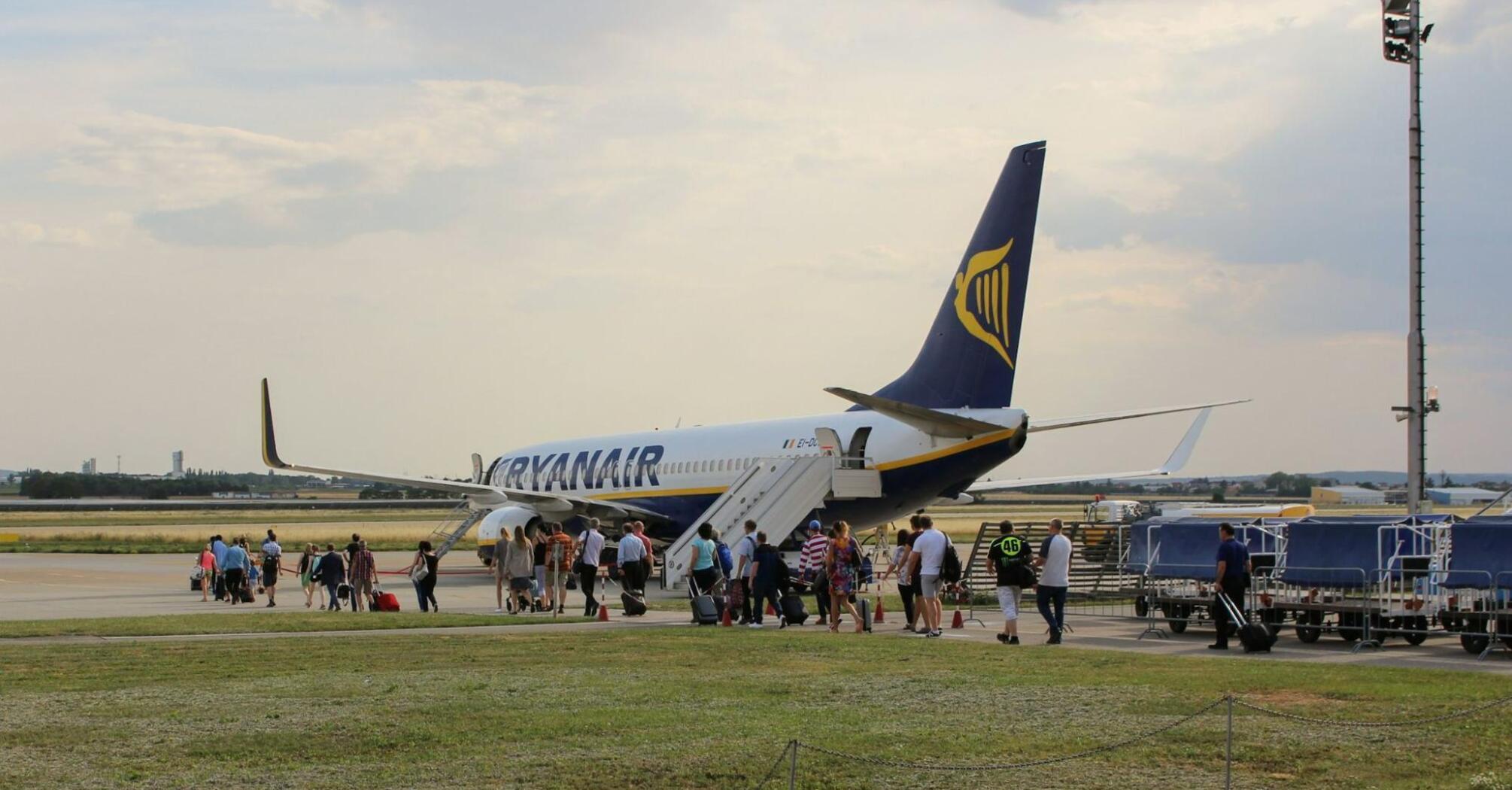 Passengers boarding a Ryanair aircraft at a regional airport.