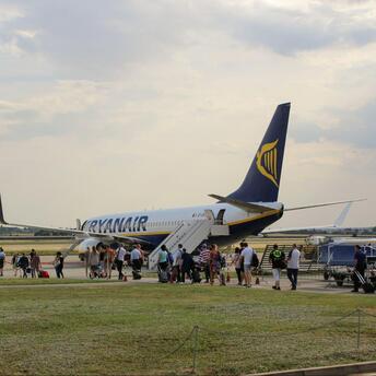 Passengers boarding a Ryanair aircraft at a regional airport.