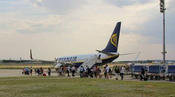 Passengers boarding a Ryanair aircraft at a regional airport.