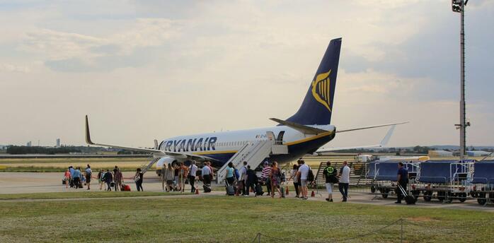 Passengers boarding a Ryanair aircraft at a regional airport.