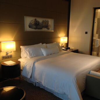 Modern hotel room with double bed and soft lighting