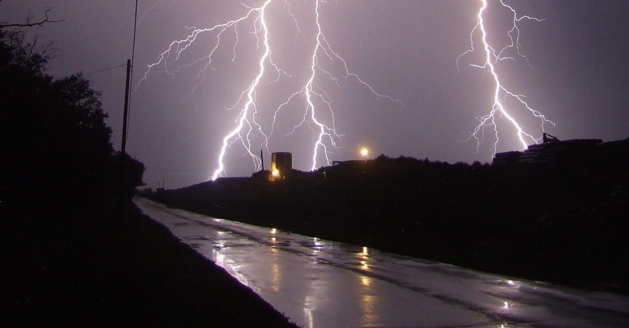 Intense lightning strike illuminating a stormy night sky