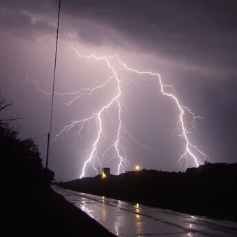 Intense lightning strike illuminating a stormy night sky