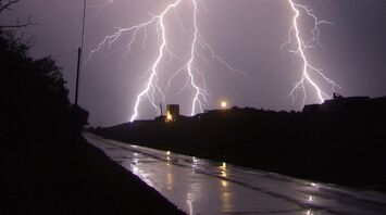 Intense lightning strike illuminating a stormy night sky