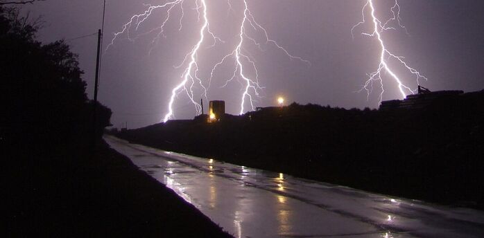Intense lightning strike illuminating a stormy night sky