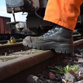 Rail worker inspecting track during maintenance