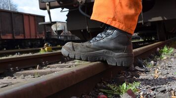 Rail worker inspecting track during maintenance