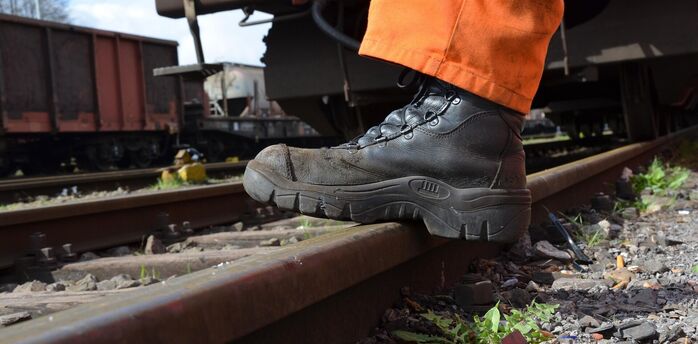 Rail worker inspecting track during maintenance