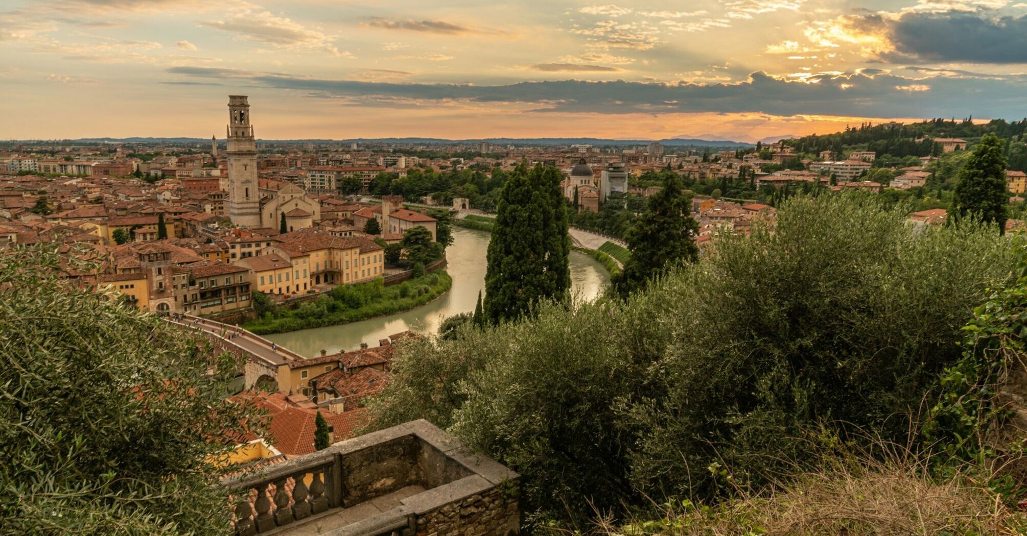 Sunset over Verona’s historic rooftops and the Adige River as seen from a hillside viewpoint