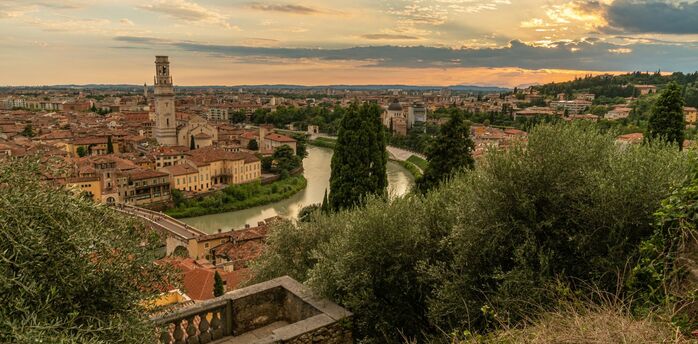 Sunset over Verona’s historic rooftops and the Adige River as seen from a hillside viewpoint