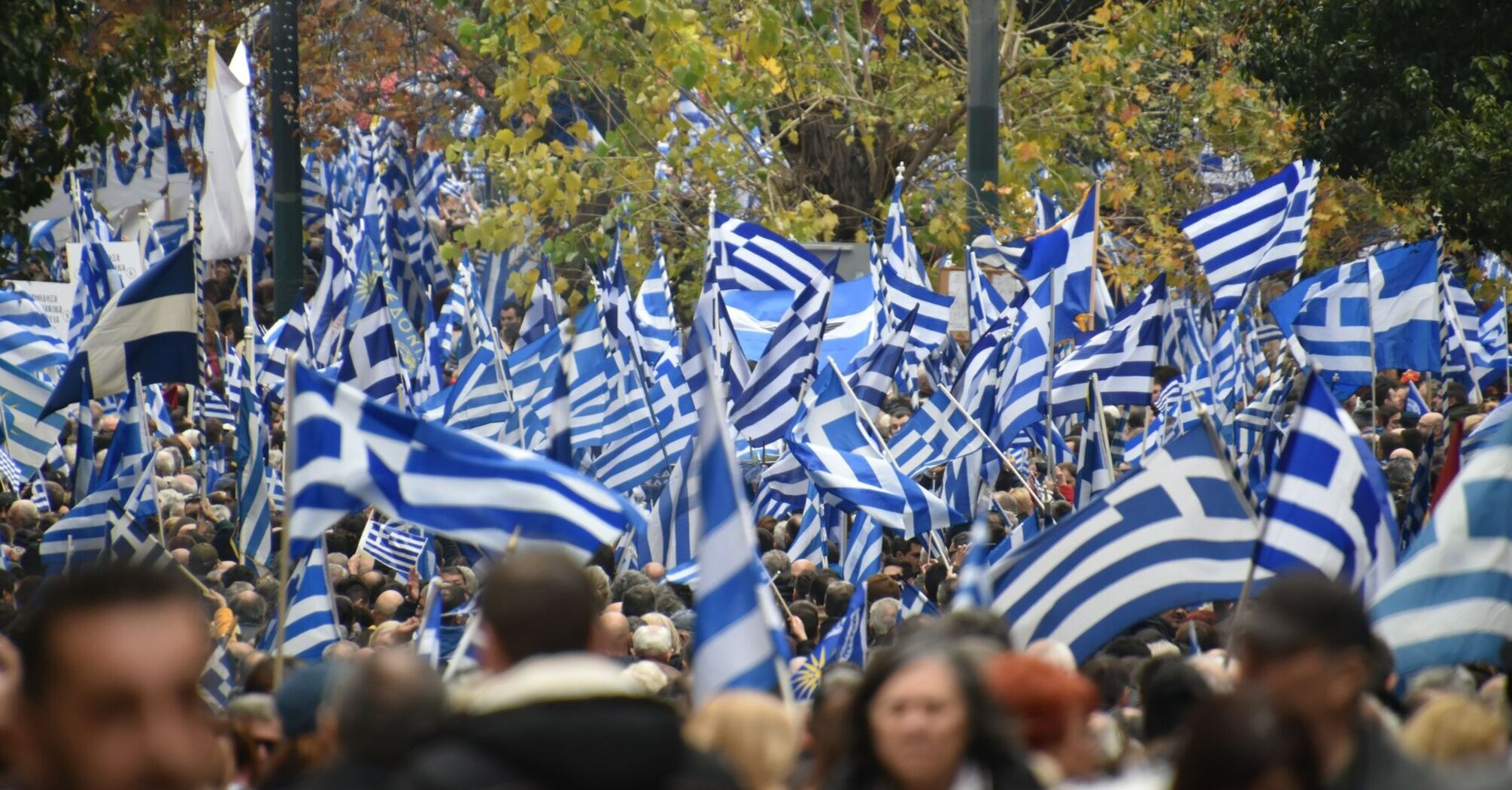 Large crowd carrying Greek flags during demonstrations in Greece