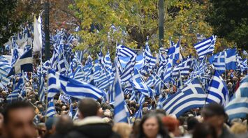Large crowd carrying Greek flags during demonstrations in Greece