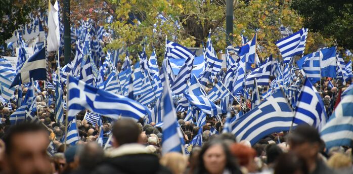 Large crowd carrying Greek flags during demonstrations in Greece