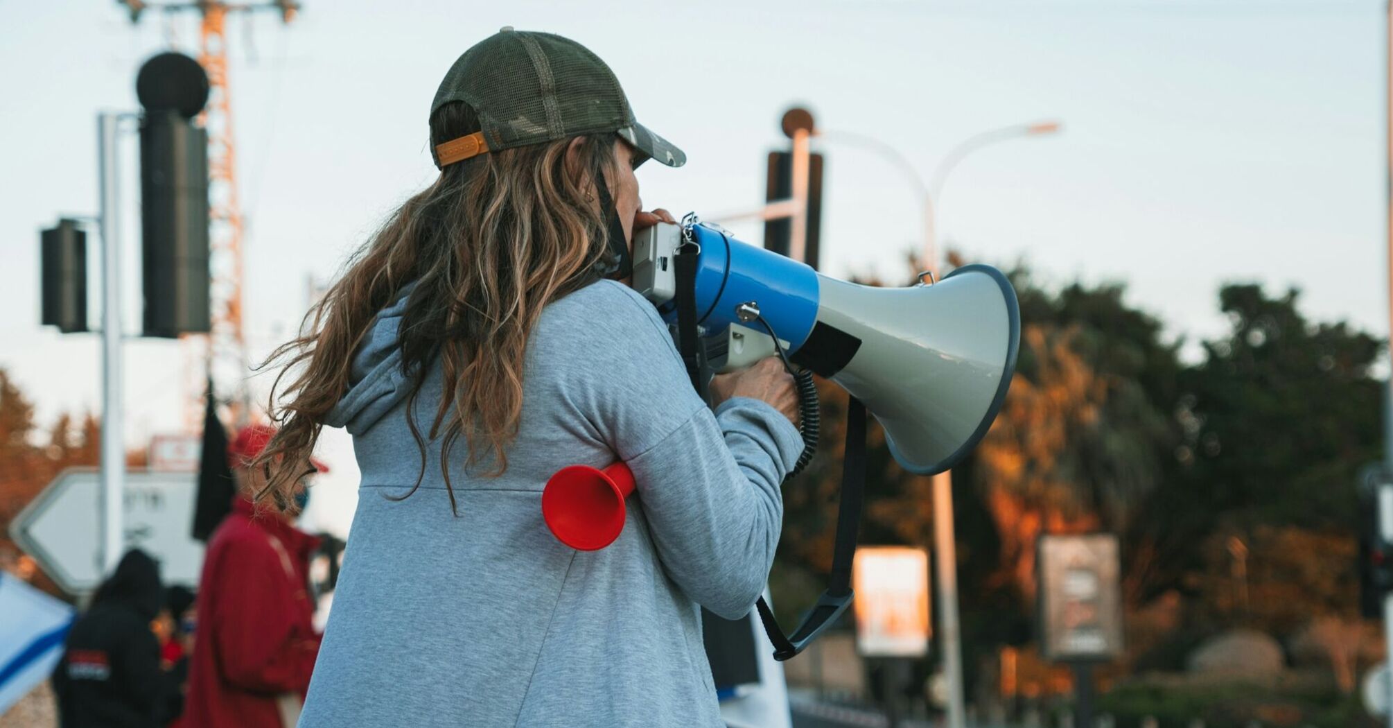 A woman with a megaphone leading a protest on a city street