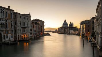 Grand Canal in Venice at sunset with historic buildings and Basilica di Santa Maria della Salute in the background