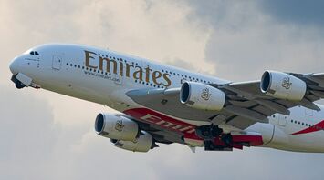 Emirates Airbus A380 taking off against a cloudy sky