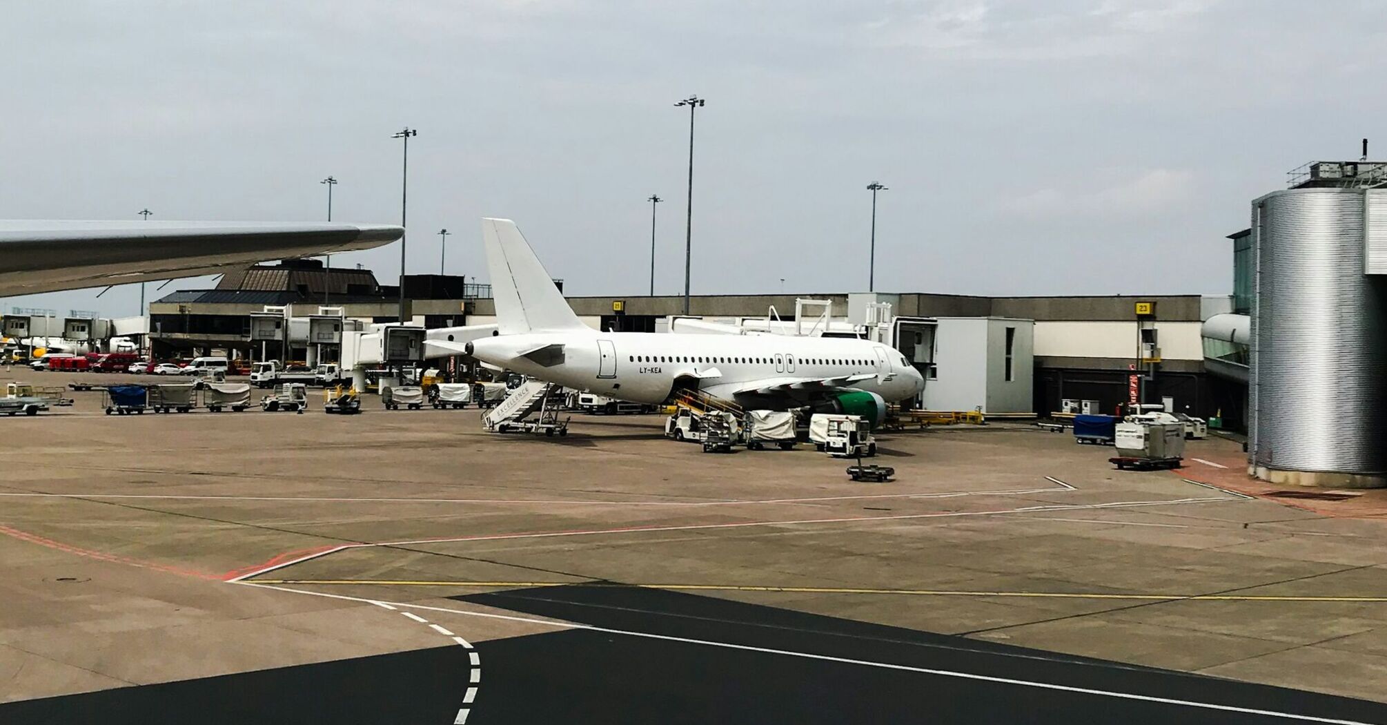 A commercial airplane parked on a busy Manchester airport tarmac