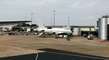 A commercial airplane parked on a busy Manchester airport tarmac