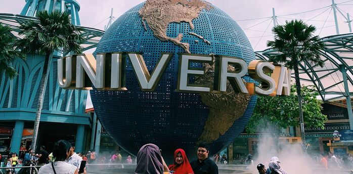 Universal Studios Singapore entrance with the iconic rotating globe and visitors taking photos