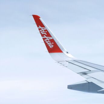 AirAsia airplane wingtip with logo against a blue sky