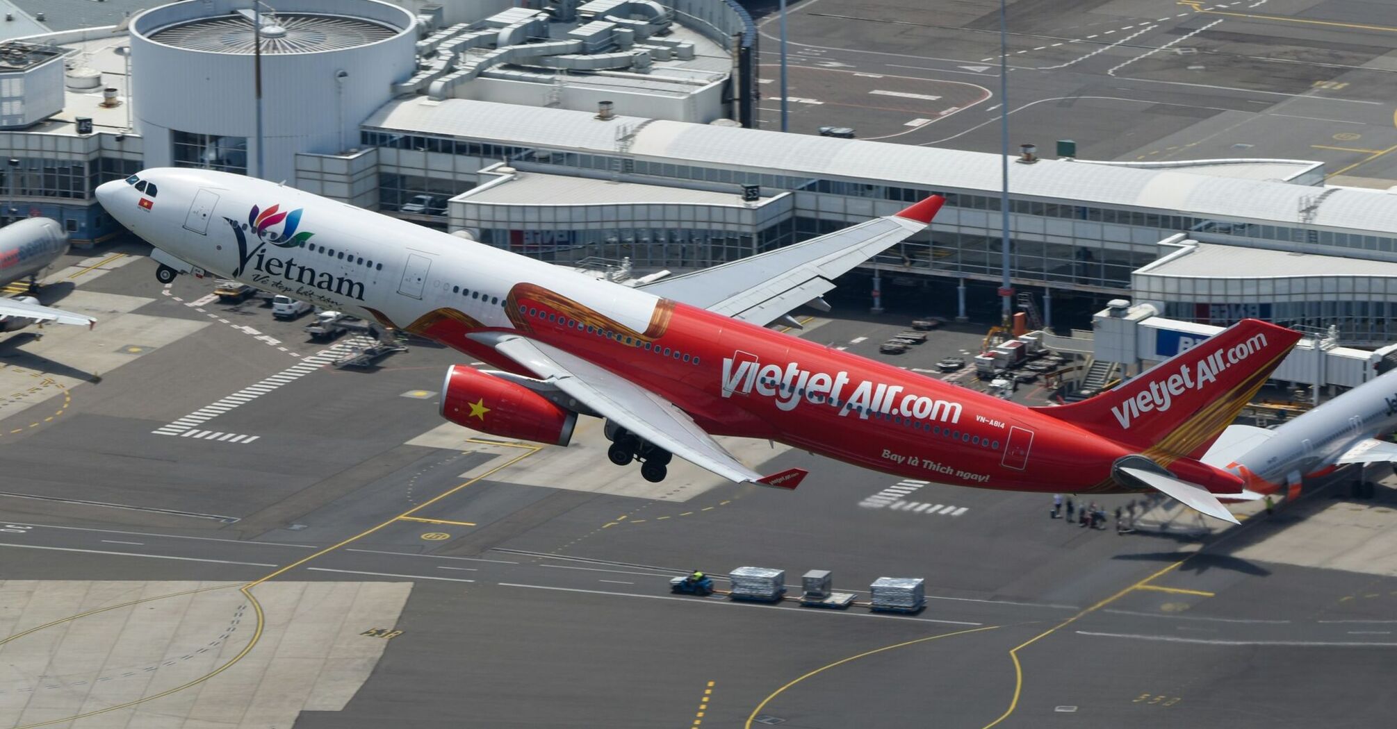 Vietjet Air aircraft taking off from an airport, showcasing its red and white livery with "VietjetAir.com" branding