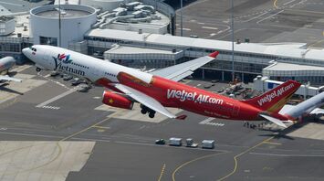 Vietjet Air aircraft taking off from an airport, showcasing its red and white livery with "VietjetAir.com" branding