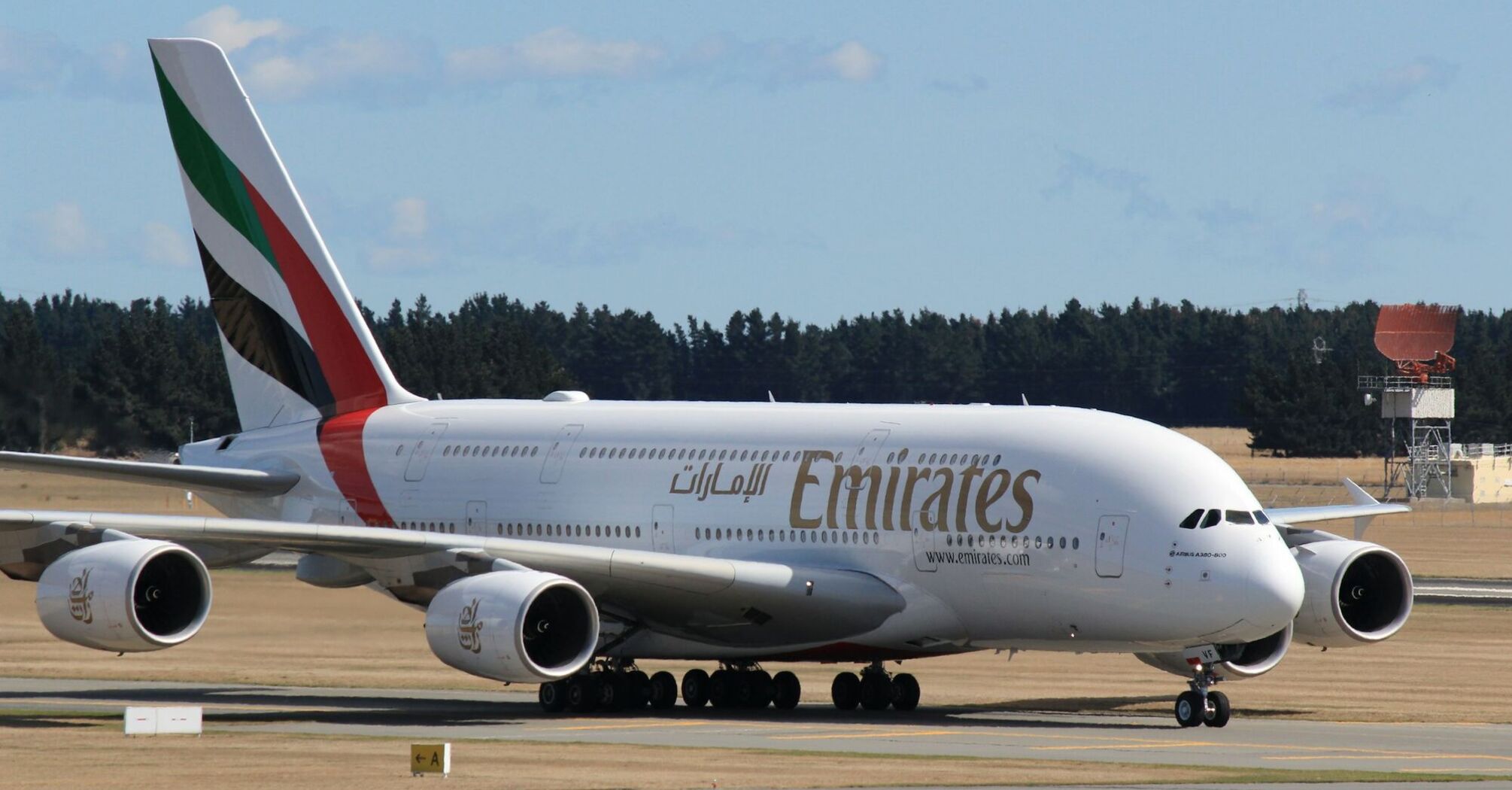 Emirates plane taxiing on the runway at an airport