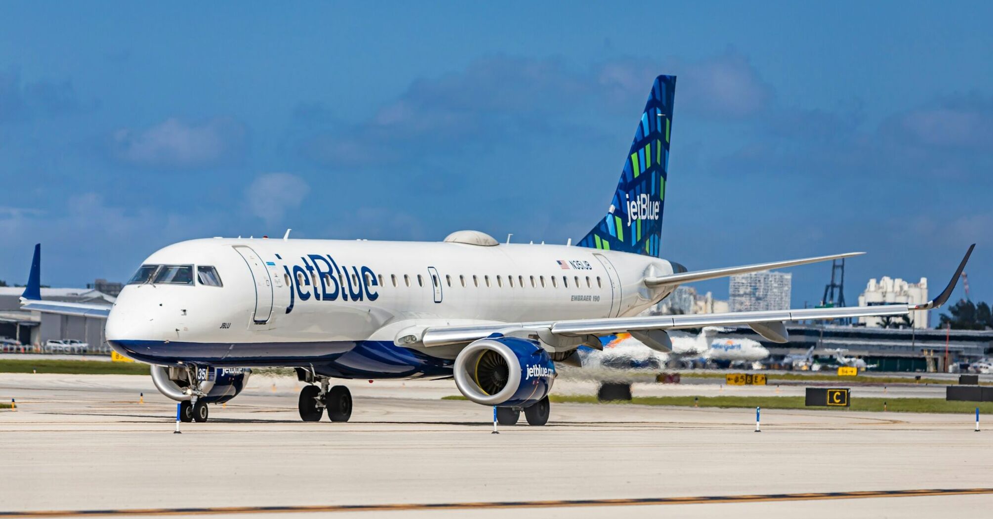 JetBlue plane taxiing on the runway at an airport